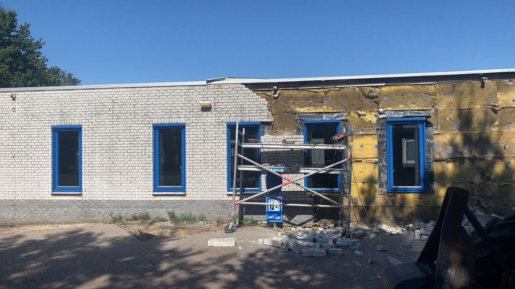Gevel van bedrijfspand in Staphorst gestript tot op de isolatie, met kozijnen nog op hun plek