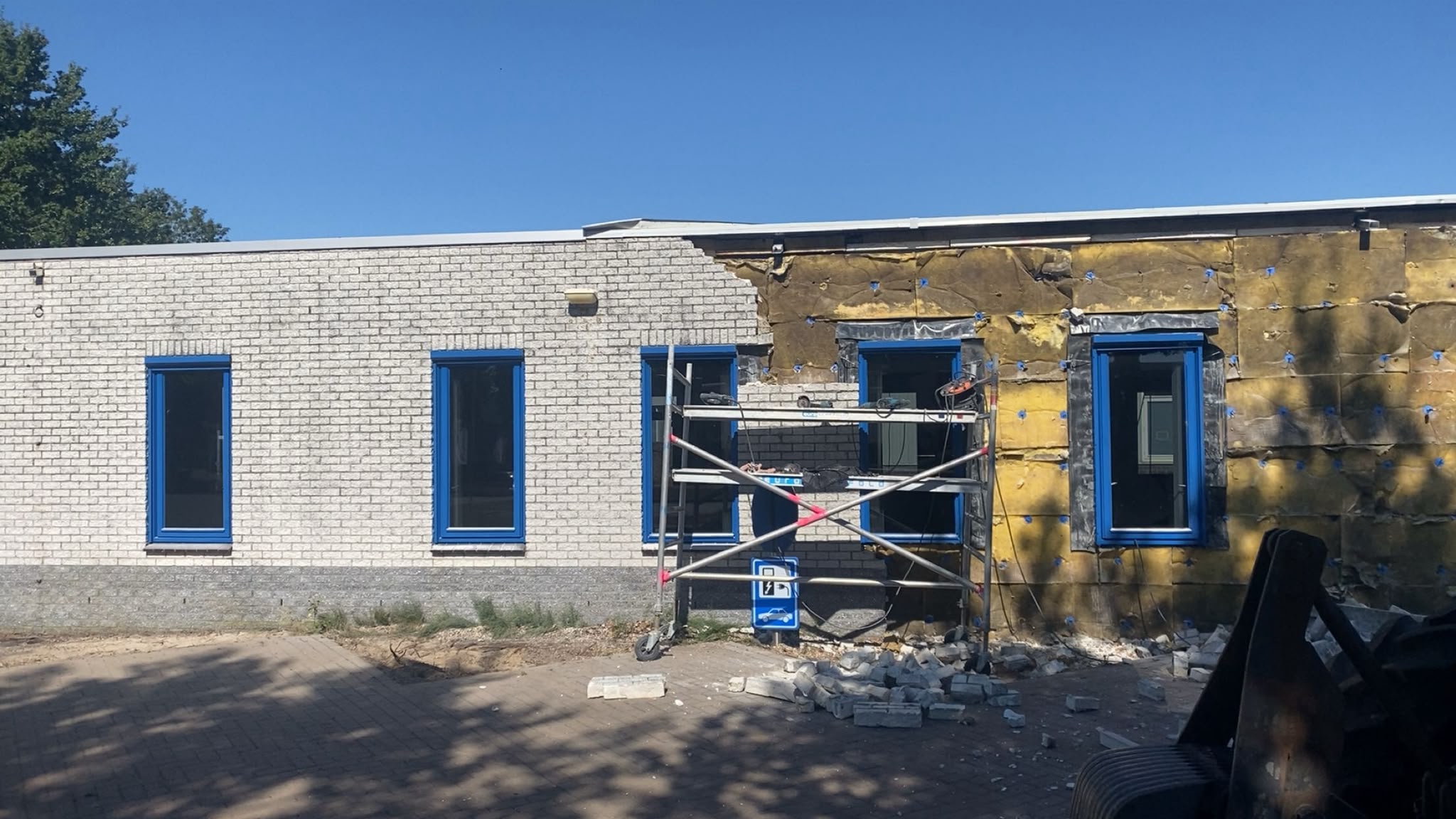 Gevel van bedrijfspand in Staphorst gestript tot op de isolatie, met kozijnen nog op hun plek